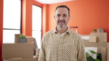 Middle age man smiling confident holding blackboard at new home