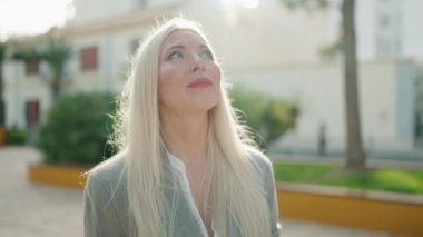 Young blonde woman executive smiling confident standing at park