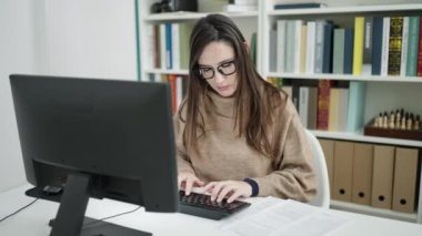 Kütüphanedeki bilgisayar okuma belgesini kullanan güzel İspanyol kadın öğrenci.