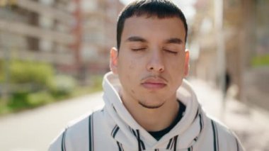 Sokakta kendine güvenen genç adam gülümsüyor