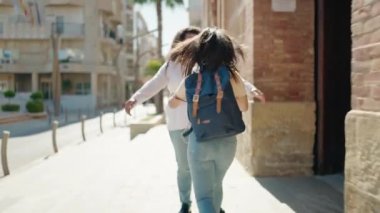 Anne ve kızı gülümsüyor, sokakta birbirlerine sarılıyorlar.