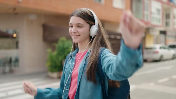 ストリートで音楽を聴く愛らしい女の子学生 — ストック動画