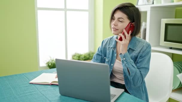 Mujer Caucásica Joven Hablando Teléfono Inteligente Utilizando Ordenador Portátil Casa — Vídeo de stock