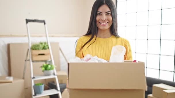 Young Beautiful Hispanic Woman Smiling Confident Holding Package New Home — Stockvideo