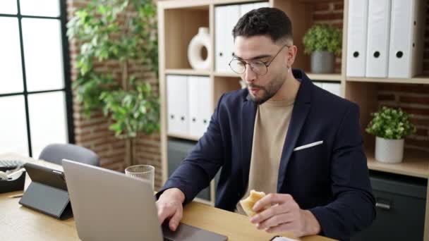 若いアラブ人のビジネスマンが朝食をオフィスで働いている — ストック動画