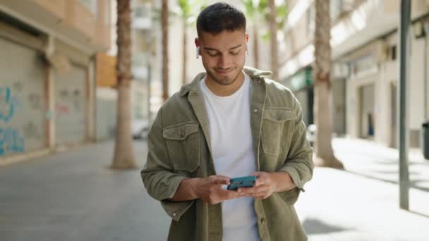 Young Hispanic Man Smiling Confident Using Smartphone Walking Street — Stock Video