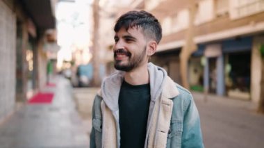 Sokakta kendinden emin gülümseyen İspanyol genç adam.