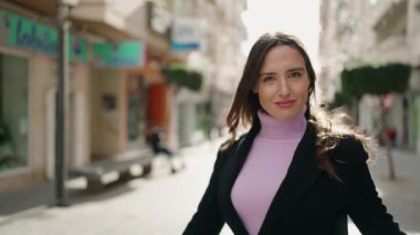 Sokakta kendine gülen genç İspanyol kadın.