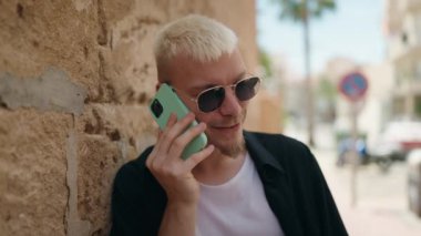 Young caucasian man smiling confident talking on smartphone at street