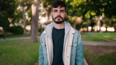 Parkta kendinden emin gülümseyen İspanyol genç adam.