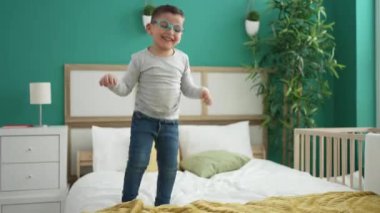 Kadın ve bebek gülümsüyor. Yatakta zıplayan kendinden emin.