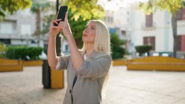 Parktaki akıllı telefondan genç sarışın kadın yönetici kayıt videosu.