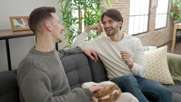 Twee Mannen Paar Zitten Bank Met Hond Spreken Thuis — Stockvideo