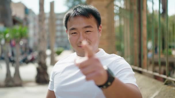 若いです中国人男笑顔自信を持ってやってジェスチャーとともに指でストリート — ストック動画