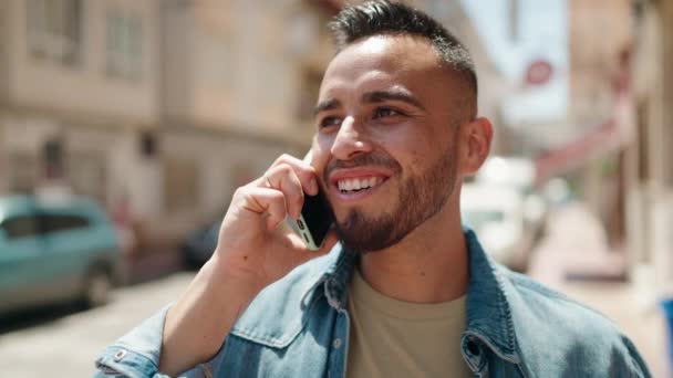 Jonge Spaanse Man Glimlacht Vol Vertrouwen Praten Smartphone Straat — Stockvideo