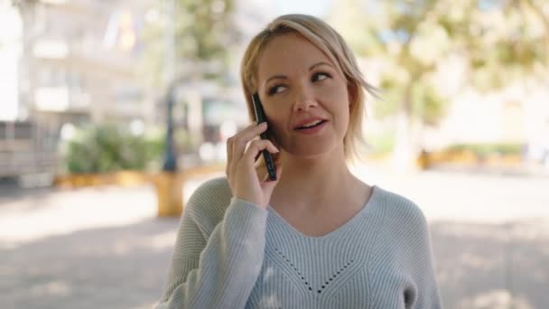 Mujer Rubia Joven Sonriendo Confiada Hablando Teléfono Inteligente Parque — Vídeo de stock