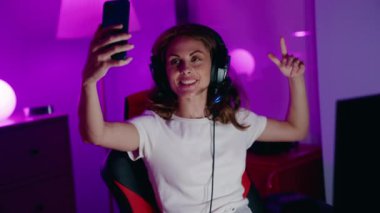 Young beautiful hispanic woman streamer smiling confident having video call at gaming room