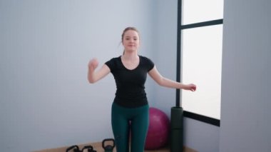 Genç sarışın kadın gülümsüyor spora atlarken kendinden emin.