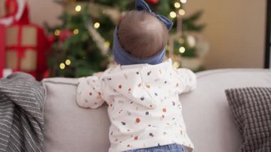 Evdeki Noel ağacının yanında kendine güvenen sevimli çocuk.