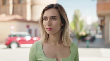 Sokakta kendinden emin gülümseyen genç bir kadın