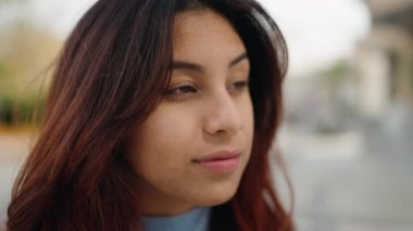 Sokakta kendine gülen genç İspanyol kadın.