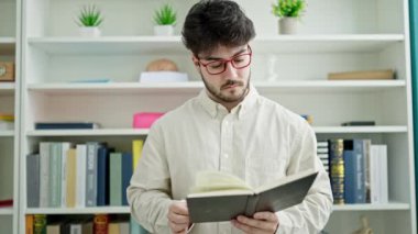 Genç İspanyol öğrenci kütüphane üniversitesinde kitap okuyor.