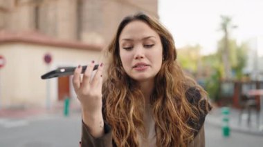 Genç İspanyol kadın gülümsüyor. Kendine güveniyor. Akıllı telefondan konuşuyor.