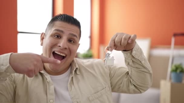 Junger Hispanischer Mann Lächelt Selbstbewusst Und Zeigt Auf Schlüssel Neuen — Stockvideo