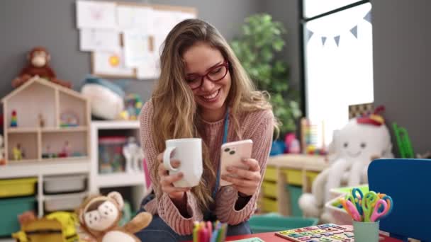 Young Beautiful Hispanic Woman Preschool Teacher Using Smartphone Drinking Coffee — Stockvideo