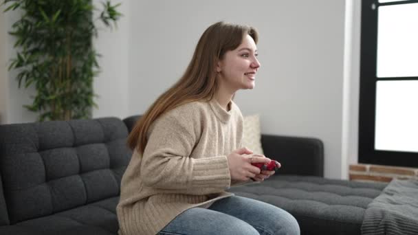Young Blonde Woman Playing Video Game Sitting Sofa Home — Vídeo de Stock