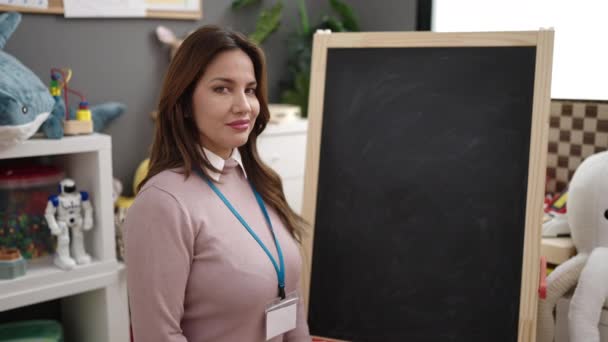 Young Beautiful Hispanic Woman Preschool Teacher Holding Chalk Kindergarten — Vídeos de Stock