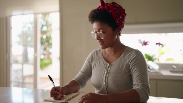 Femeie Afro Americană Scrie Notebook Care Stă Masă Acasă — Videoclip de stoc