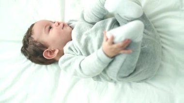 Sevimli İspanyol bebek yatakta uzanıp ağlıyor.