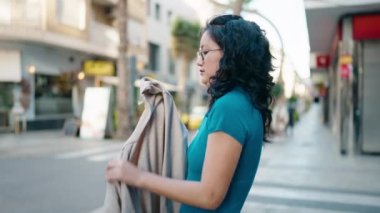 Sokakta kendine güvenen genç Çinli kadın ceketini giyiyor.