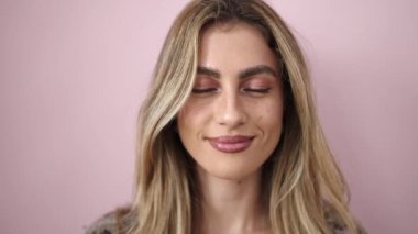 Young blonde woman smiling confident standing over isolated pink background