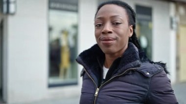 Sokakta kendine güvenen Afrikalı Amerikalı kadın gülümsüyor