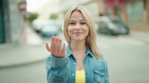 Genç Sarışın Kadın Gülümsüyor Kendinden Emin Sokakta Kol Hareketi Yapıyor — Stok video