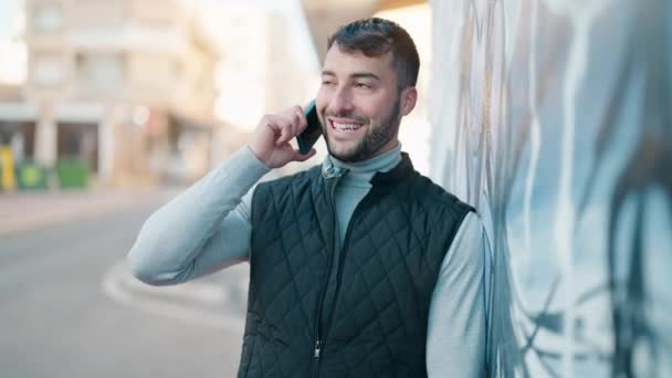 Joven Hombre Hispano Sonriendo Confiado Hablando Teléfono Inteligente Calle — Vídeo de stock