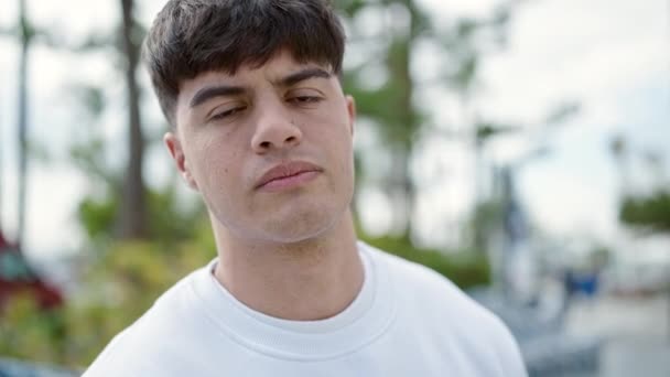 Young Hispanic Man Standing Serious Expression Walking Away Park — Stock Video