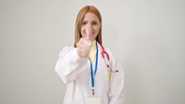 Jovem Loira Médico Sorrindo Confiante Fazendo Gesto Sobre Fundo Branco — Vídeo de Stock