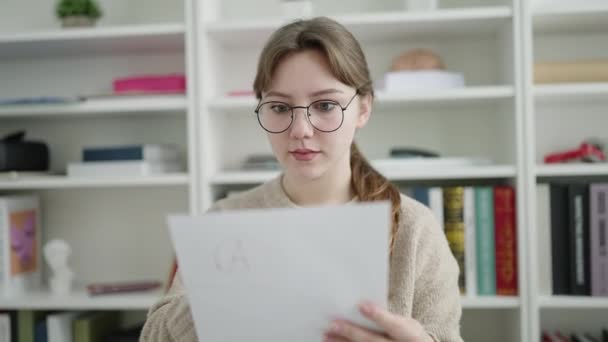 若いですブロンド女性学生読書文書で図書館大学 — ストック動画