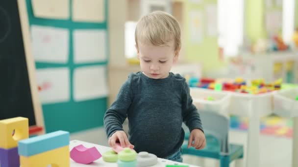 Liebenswertes Blondes Kleinkind Spielt Kindergarten Mit Geometrieblöcken — Stockvideo