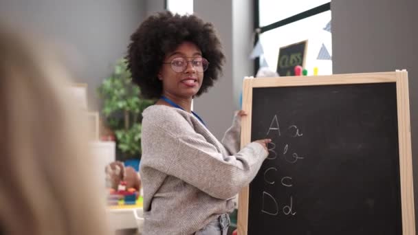 African American Woman Teacher Smiling Confident Writing Blackboard Kindergarten — Vídeos de Stock