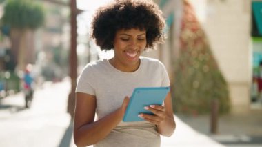 Sokakta dokunmatik ped kullanan, kendine güvenen genç Afro-Amerikan kadın.