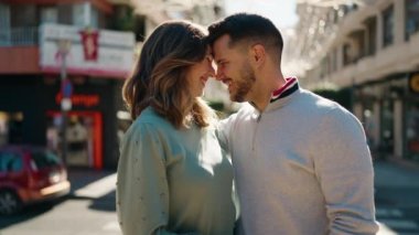 Young couple kissing and hugging each other standing at street