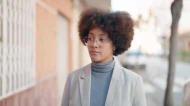 Sokakta ciddi bir ifadeyle duran Afrikalı Amerikalı kadın.