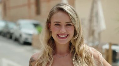 Sokakta kendine güvenen genç sarışın kadın gülümsüyor
