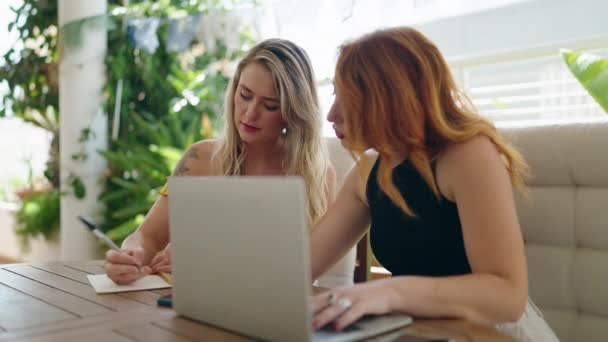 Дві Жінки Використовуючи Ноутбук Пишуть Ноутбуці Сидячи Столі Домашній Терасі — стокове відео