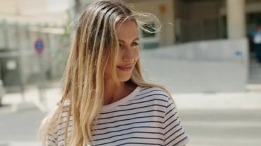 Young blonde woman smiling confident looking to the side at street