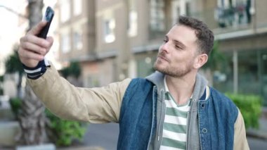 Young caucasian man smiling confident taking selfie picture at street